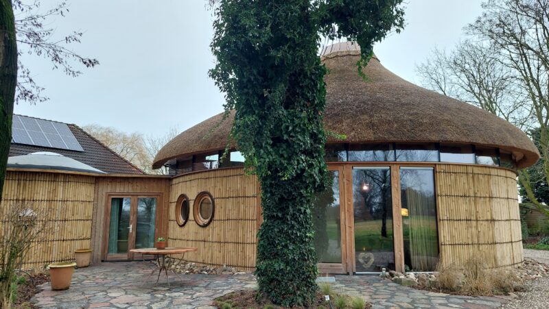 Ronde spiraalwoning met rieten dak en natuurlijke materialen als voorbeeld van organische architectuur