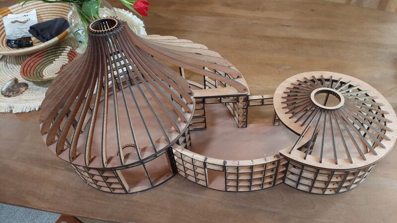 Maquette van een dubbele slakkenhuis spiraalwoning met houten ribben en ronde vorm