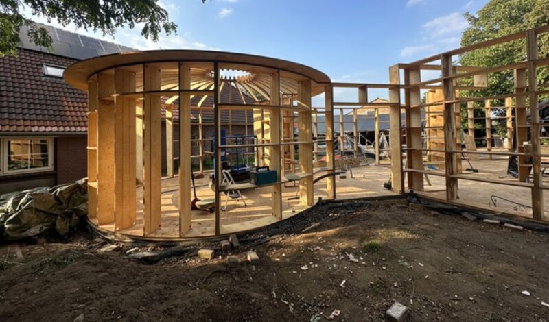 Constructie van een ronde spiraalwoning met houten spanten als voorbeeld van organische architectuur
