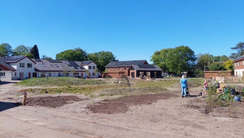 Gemeenschappelijke buitenruimte met bewoners in ecologische woonwijk De Glind