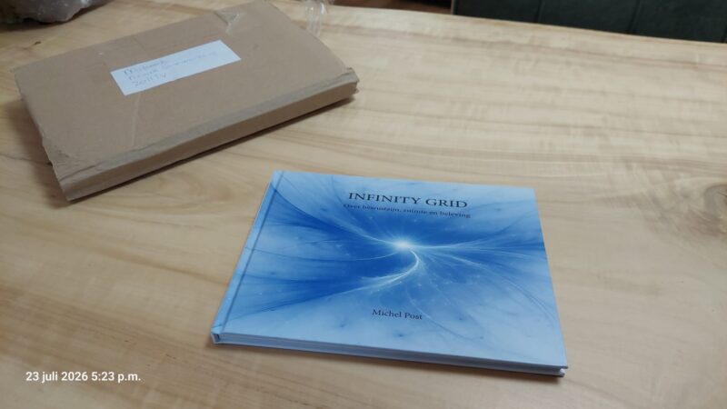 Eerste proefdruk van het boek Infinity Grid op tafel naast de verzendverpakking.