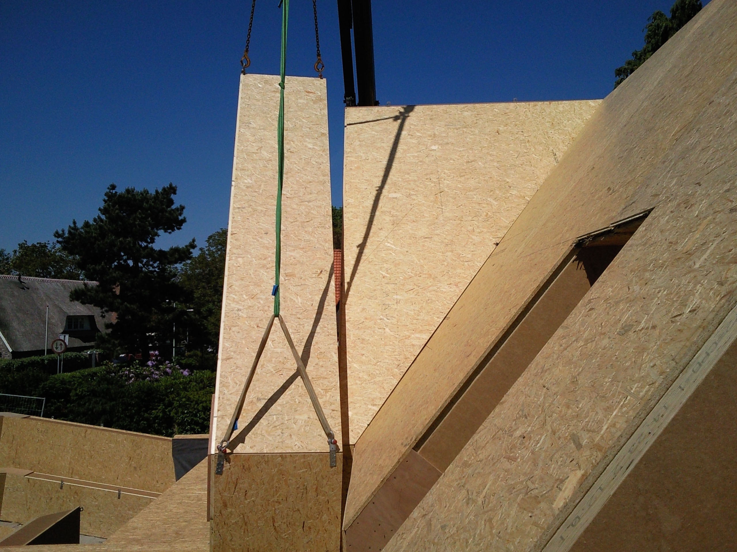 Prefab wandelement met de kraan gehesen op de bouwplaats
